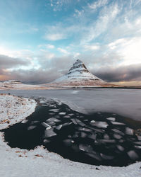 Scenic view of lake against cloudy sky during winter