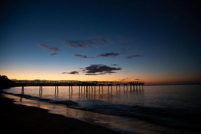 Pier over sea against sky during sunset