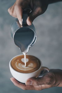 Midsection of man pouring coffee in cup