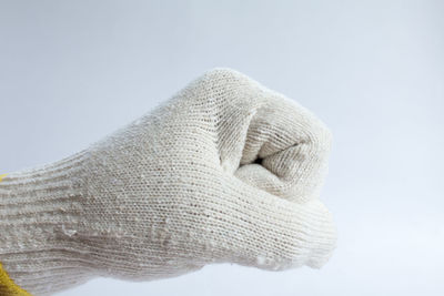 Close-up of hand covering face against white background