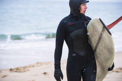 Young woman going winter surfing in snow