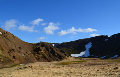 Spring thaw around a valley with snow melting on surrounding mountains.