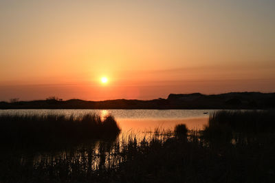 Scenic view of lake against romantic sky at sunset