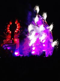 Low angle view of illuminated fireworks against sky at night