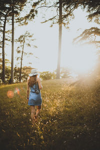 Rear view of woman walking on field