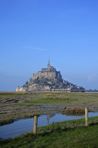 Mont saint michel against blue sky, reflection in the water normandy