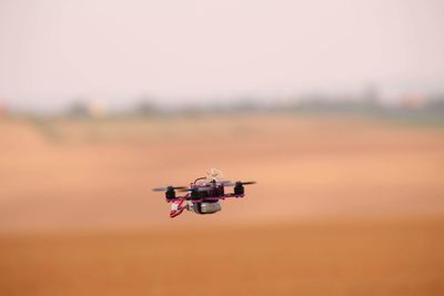 Airplane flying over land against sky
