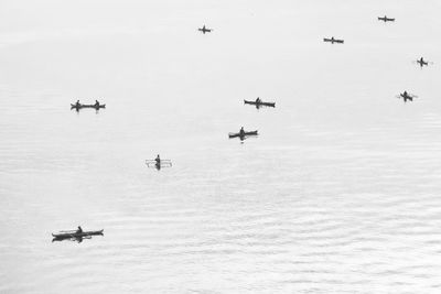High angle view of airplane flying over sea against sky