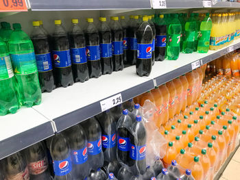 Close-up of multi colored bottles in shelf at store