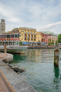 Bridge over river by buildings against sky