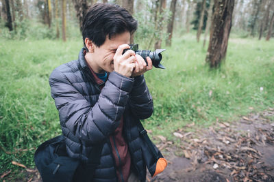 Young man photographing camera on field