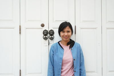 Portrait of smiling woman by door