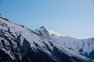 Scenic view of snowcapped mountains against clear sky