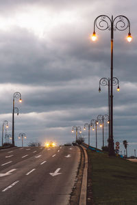 Street lights against sky at sunset