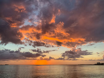 Scenic view of sea against dramatic sky during sunset