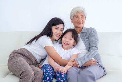 Happy friends sitting on sofa at home