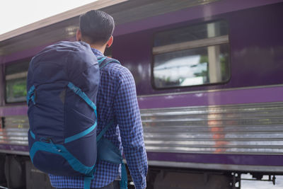 Rear view of man standing at railroad station