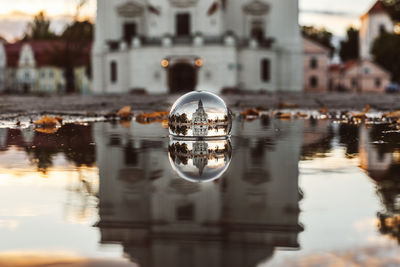 Reflection of church on crystal ball in puddle