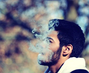 Close-up of young man smoking outdoors