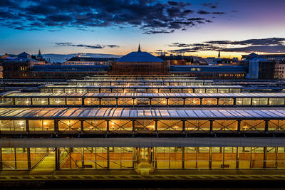 Illuminated buildings against sky at sunset