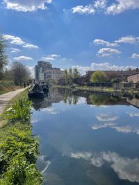 Scenic view of river by buildings against sky