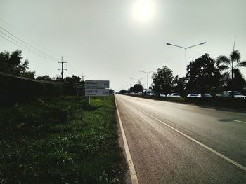 Road by trees against clear sky