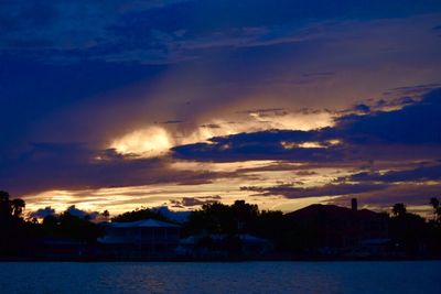 Scenic view of river against dramatic sky at sunset