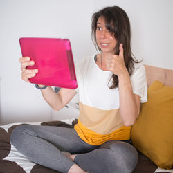 Portrait of a smiling young woman using mobile phone