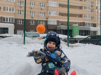 Portrait of a smiling boy sitting in the snow