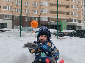 Portrait of smiling boy standing on snow