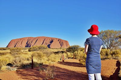 Rear view of woman wearing hat standing against sky