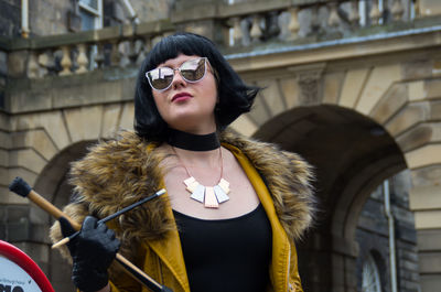 Young woman wearing sunglasses standing in city