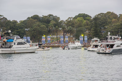 Boats moored at harbor against sky