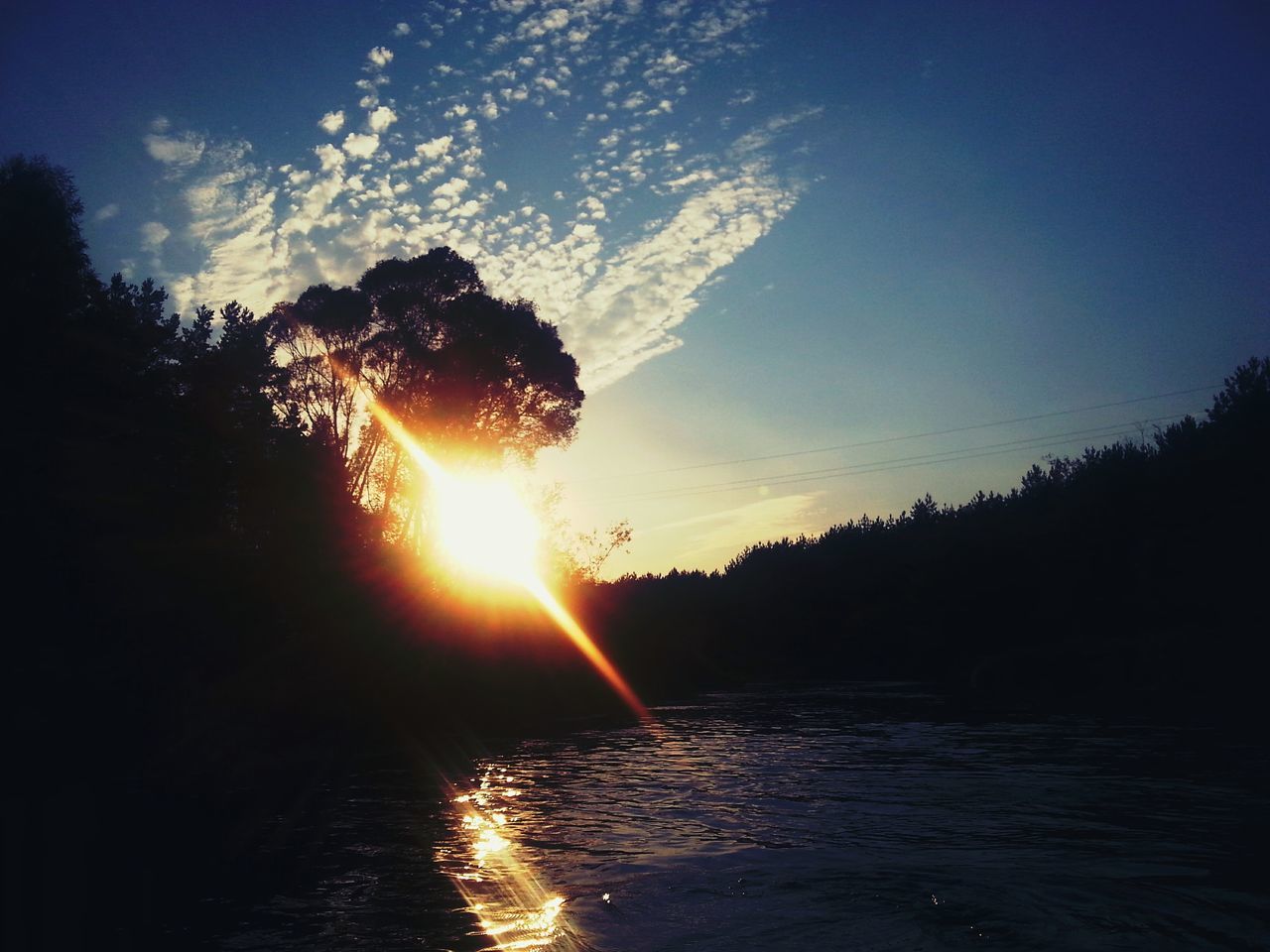 sunset, sun, water, silhouette, sky, tranquil scene, scenics, tranquility, sunlight, beauty in nature, tree, sunbeam, reflection, nature, river, waterfront, lens flare, idyllic, orange color, lake