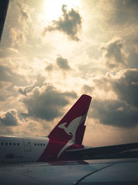 Close-up of airplane wing against sky during sunset