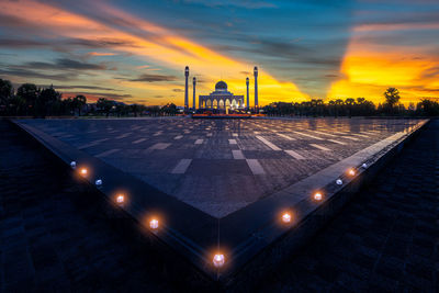Illuminated mosque against sky at sunset