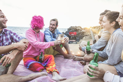 Happy friends enjoying drinks at beach