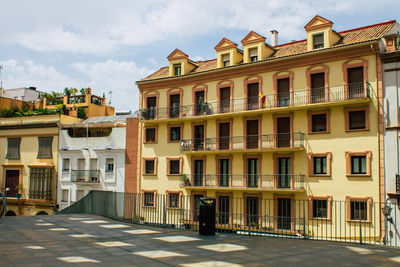 Residential buildings by street against sky