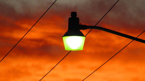 Low angle view of illuminated lamp against sky