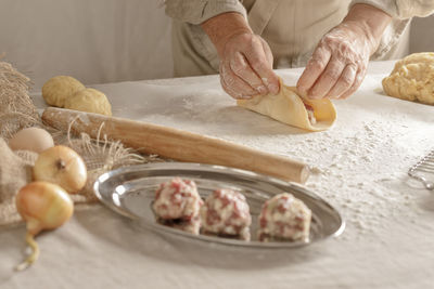 Cropped hand of person preparing food on table