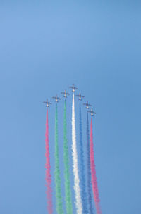 Low angle view of airshow against clear blue sky