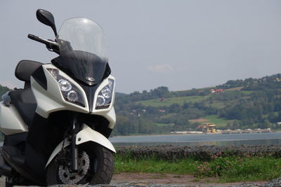 Close-up of motorcycle on road against sky