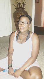 Portrait of smiling young woman sitting at home