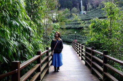 Full length portrait of woman standing on walkway at park