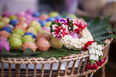 Close-up of wreath by multi colored desserts on wicker table
