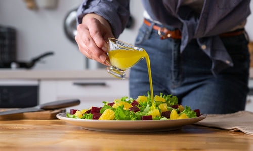 Young and beautiful housewife woman cooking in a white kitchen
