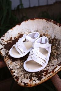 Close-up of white sandals on rusty seat