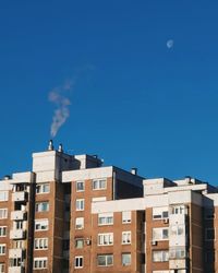 Low angle view of buildings against blue sky