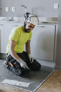 Tiler installing tiles on kitchen floor