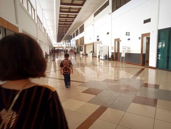 Rear view of people walking in corridor